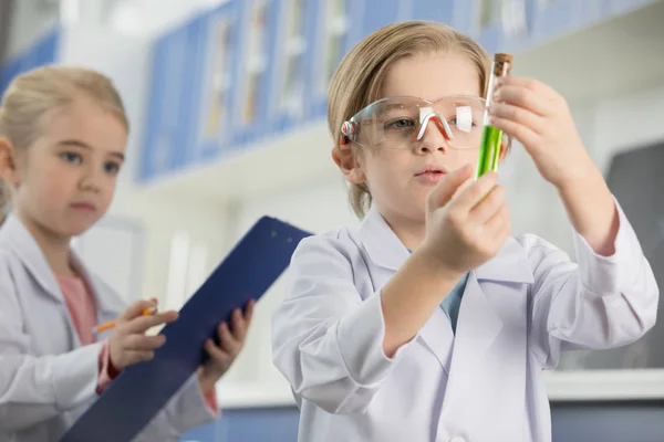 Schoolboy looking at sample — Stock Photo