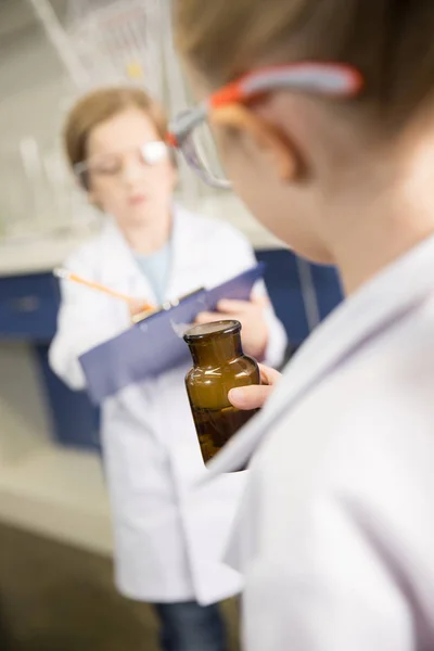 Schoolgirl holding flask — Stock Photo