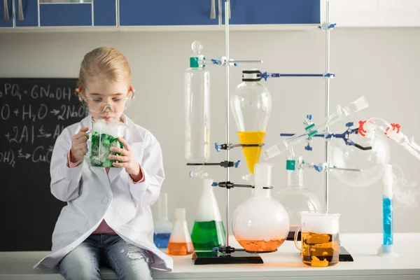 Schoolgirl holding flask with sample — Stock Photo