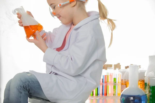 Schoolgirl holding flask with sample — Stock Photo