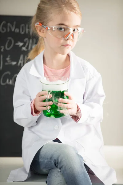 Écolière tenant fiole avec échantillon — Photo de stock