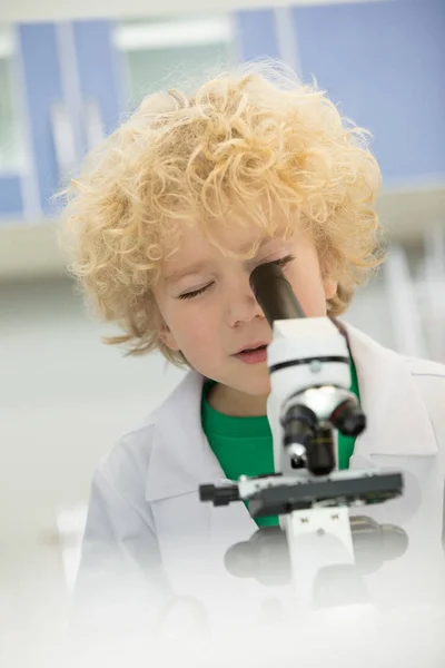 Garçon regardant à travers microscope — Photo de stock
