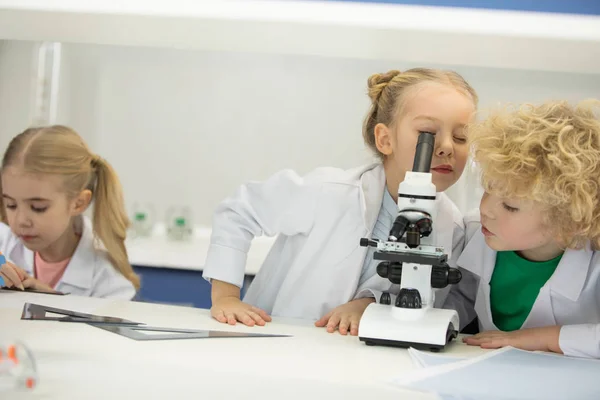 Kids looking through microscope — Stock Photo
