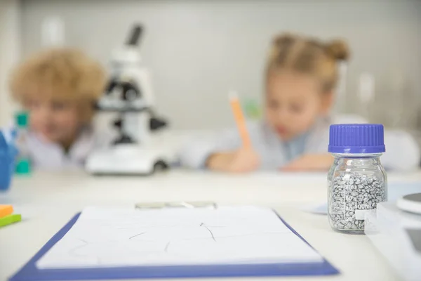 Bottle with reagent and clipboard — Stock Photo