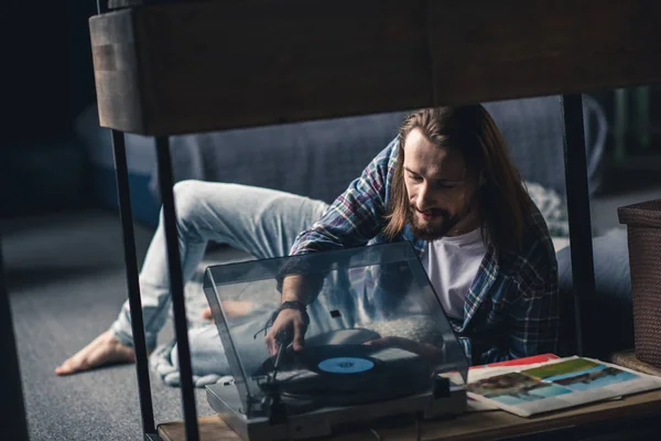 Man putting vinyl record on turntable — Stock Photo