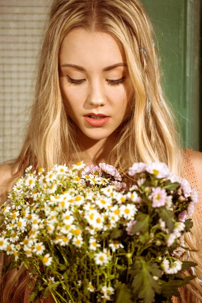 Bohemian young woman holding chamomiles — Stock Photo