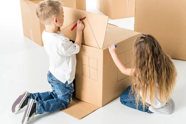 Niños dibujando en caja de cartón - foto de stock