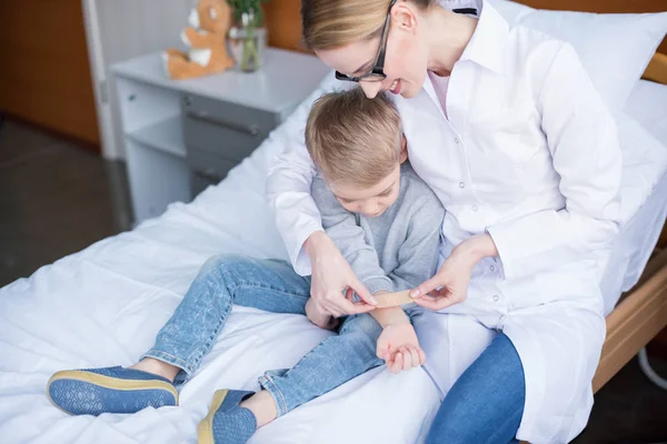 Médico y pequeño paciente - foto de stock