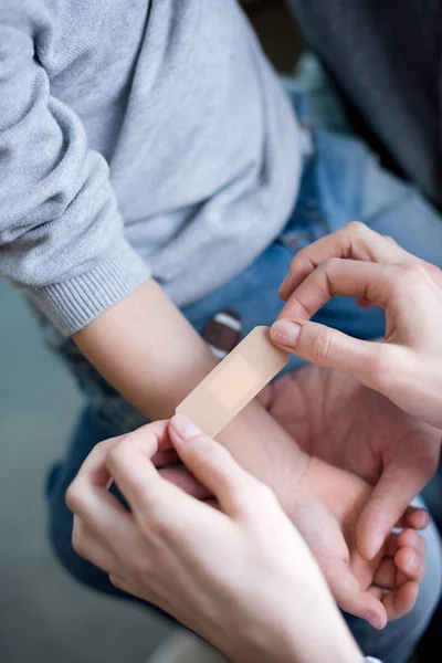 Médico poniendo parche médico en la mano — Stock Photo