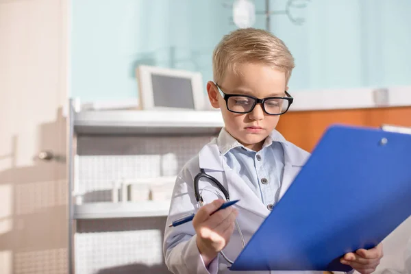 Un niño fingiendo ser médico - foto de stock