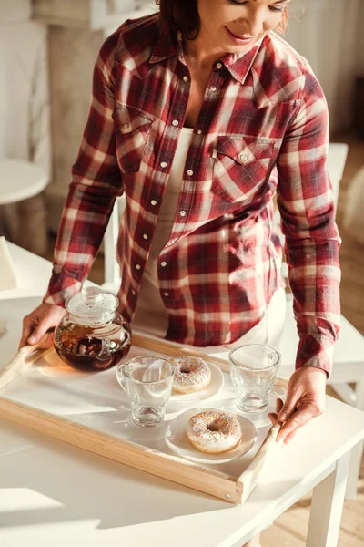 Woman holding tray with tea — Stock Photo