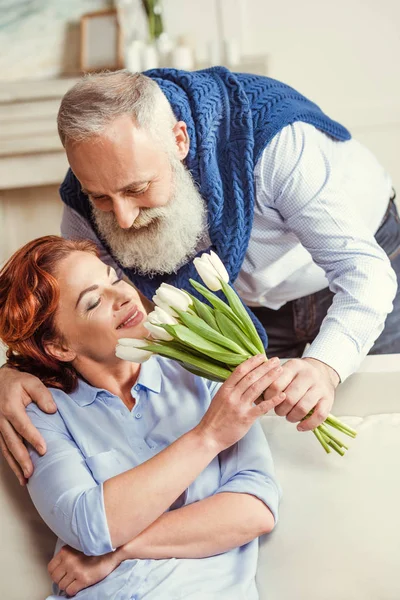 Mature couple with flowers — Stock Photo