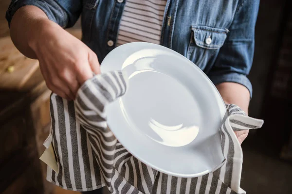 Frau wischt Teller ab — Stockfoto