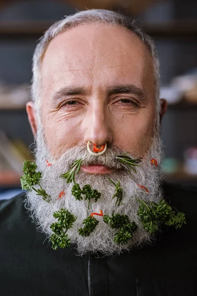 Senior man with greens in beard — Stock Photo