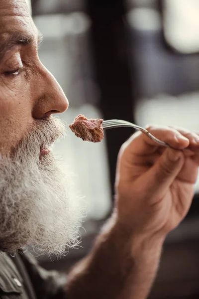 Hombre comiendo filete - foto de stock