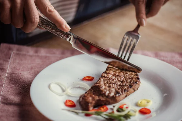 Mujer comiendo filete - foto de stock