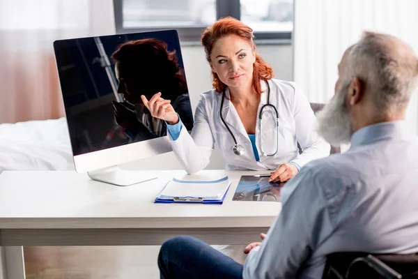 Médecin et patient en fauteuil roulant — Photo de stock