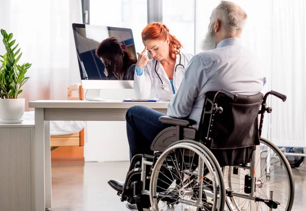 Medico e paziente in sedia a rotelle — Foto stock