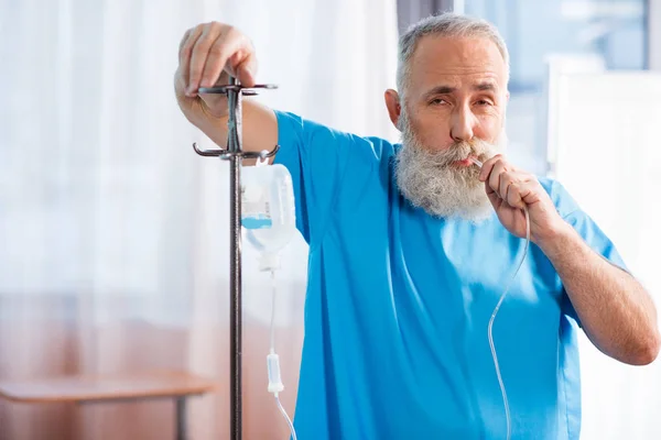 Hombre enfermo con contador de gotas - foto de stock