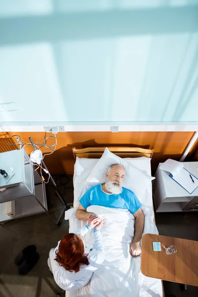 Doctor holding hand of patient — Stock Photo