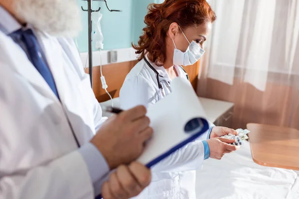 Médico femenino sosteniendo píldoras - foto de stock