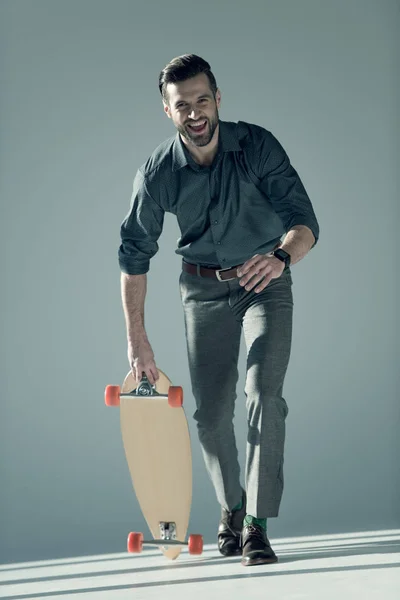 Homme élégant tenant skateboard — Photo de stock