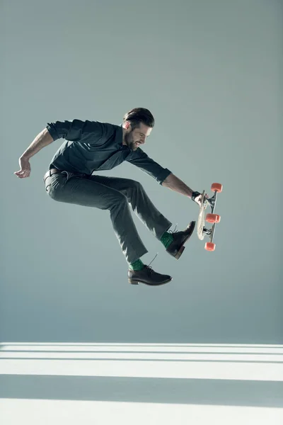 Uomo alla moda in possesso di skateboard — Foto stock