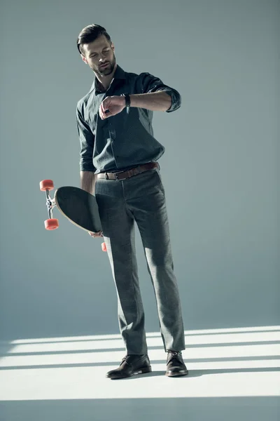 Uomo elegante in possesso di skateboard — Foto stock