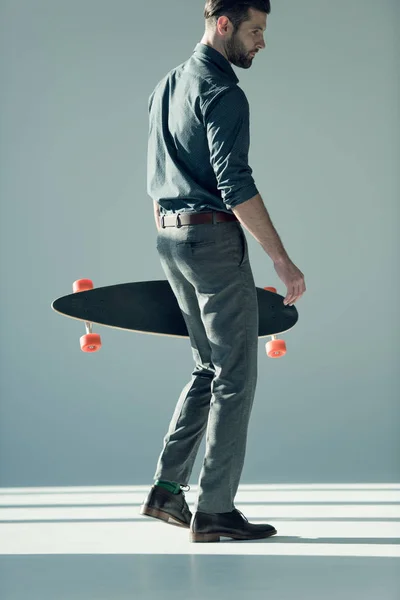 Homem elegante segurando skate — Fotografia de Stock