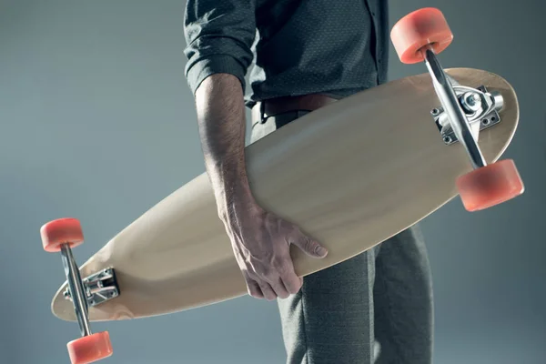 Стильный мужчина держит скейтборд — стоковое фото