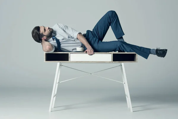 Homme d'affaires allongé sur la table — Photo de stock