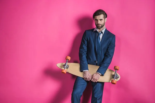 Чоловік у костюмі зі скейтбордом — стокове фото