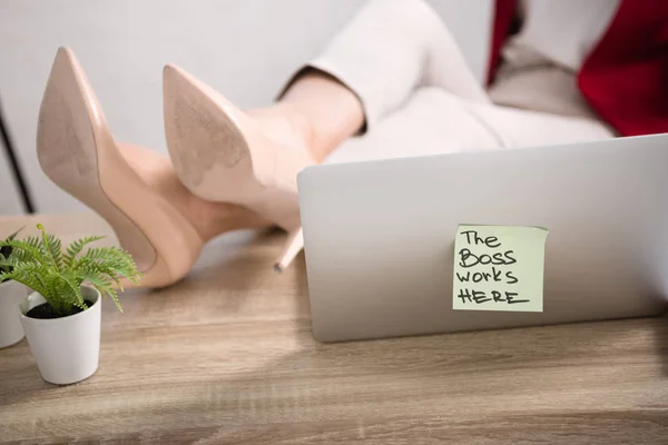 Pernas femininas perto de laptop — Fotografia de Stock