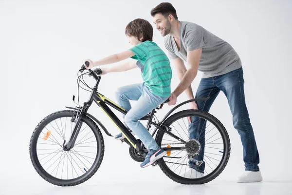 Père aider son fils à faire du vélo — Photo de stock
