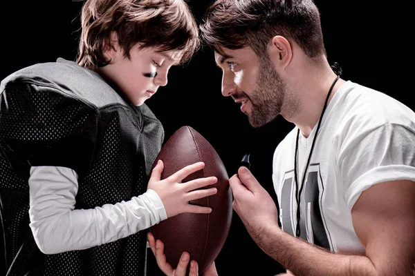 Boy playing football with trainer — Stock Photo