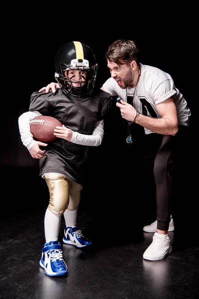 Boy playing football with trainer — Stock Photo