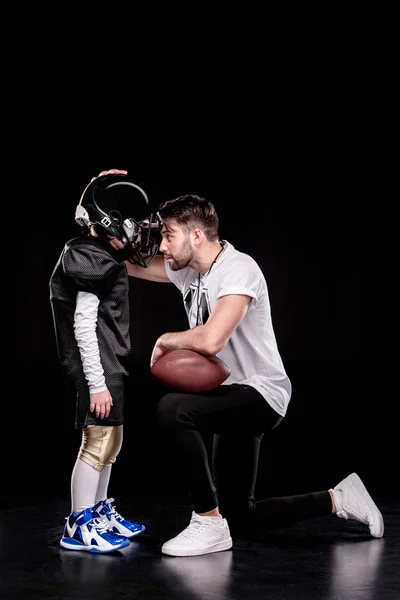 Boy playing football with trainer — Stock Photo