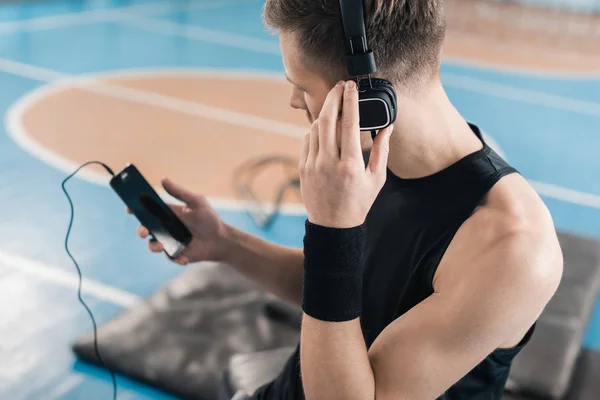 Deportista en auriculares con smartphone - foto de stock