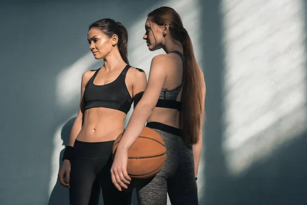 Mujeres deportivas con pelota de baloncesto - foto de stock