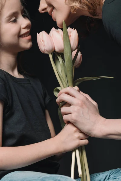 Filha e mãe com flores de tulipa — Fotografia de Stock