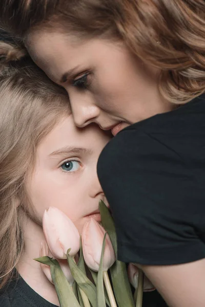 Filha e mãe com flores de tulipa — Fotografia de Stock