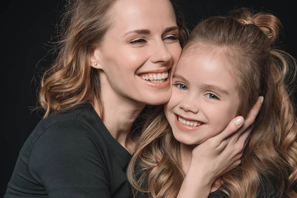 Hija y madre sonriendo - foto de stock