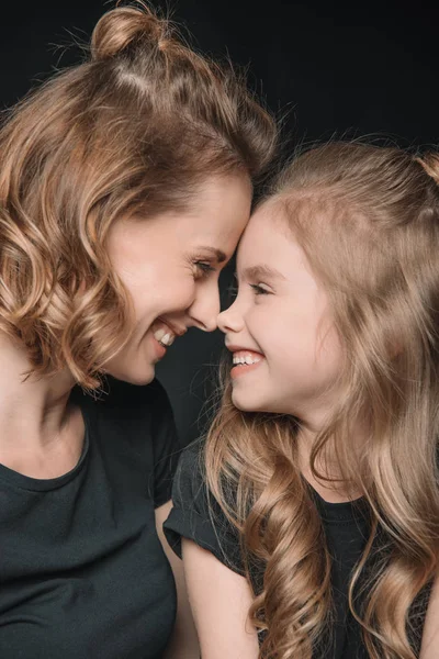 Hija y madre sonriendo - foto de stock
