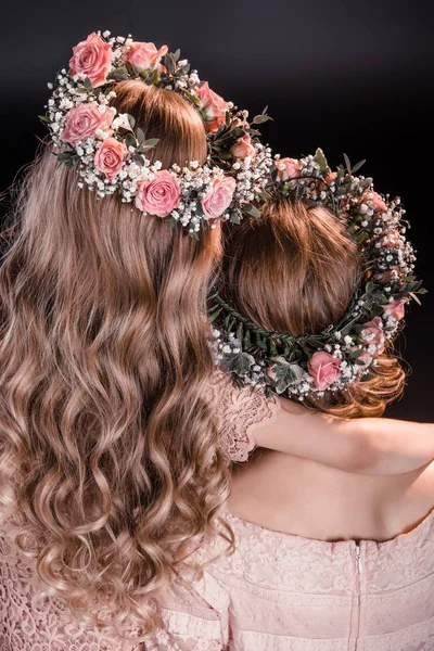 Madre e hija en flores guirnaldas - foto de stock