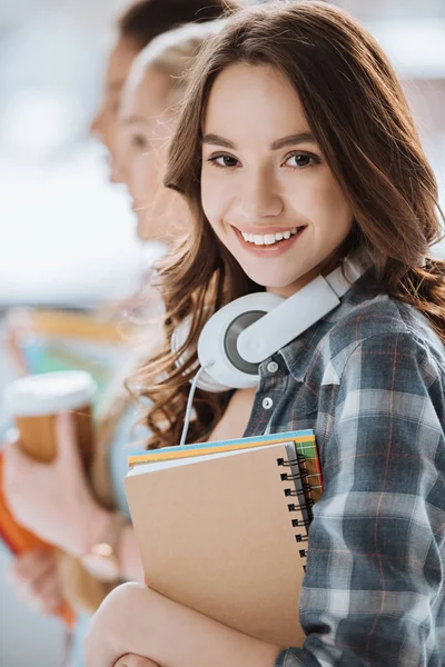 Woman with headphones and notebooks — Stock Photo