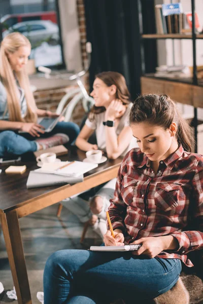 Frau studiert und schreibt in Textbuch — Stockfoto