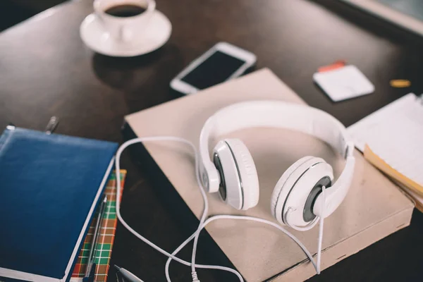 Libro y auriculares en la mesa - foto de stock