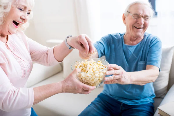 Coppia anziana mangiare popcorn — Foto stock