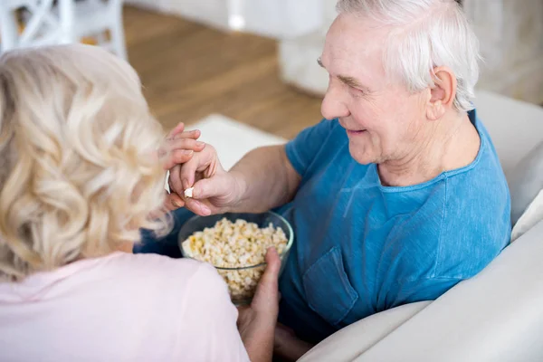 Senior couple eating popcorn — Stock Photo