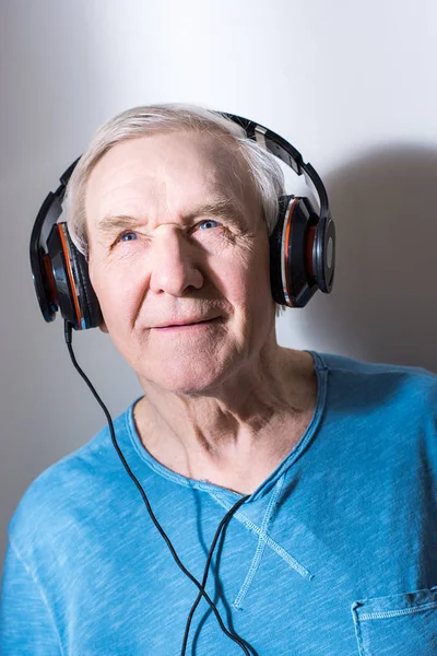 Hombre mayor en auriculares - foto de stock